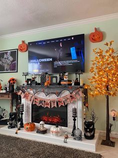 a living room decorated for halloween with decorations on the mantle and tv in the fireplace