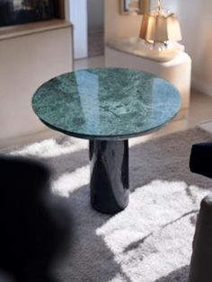 a round glass table sitting in the middle of a living room