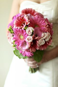 a bride holding a bouquet of pink flowers