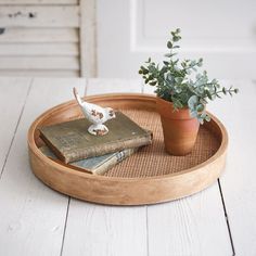 a wooden tray topped with books and a potted plant