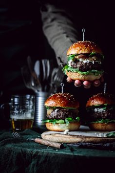 three hamburgers stacked on top of each other with toothpicks stuck in them