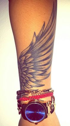 a woman's arm with tattoos and bracelets on her wrist, which is decorated with an eagle