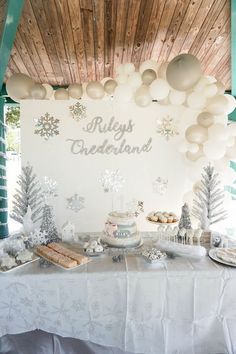 a table topped with cake and desserts under a wooden ceiling covered in snowflakes