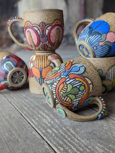 three handmade vases sitting on top of a wooden table next to each other