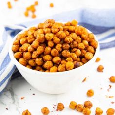 a white bowl filled with chickpeas on top of a blue and white towel