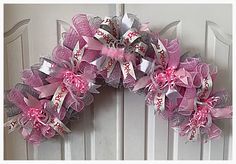 a pink and silver wreath with happy birthday written on the front, attached to a white door