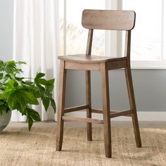 a wooden chair sitting next to a potted plant on top of a carpeted floor