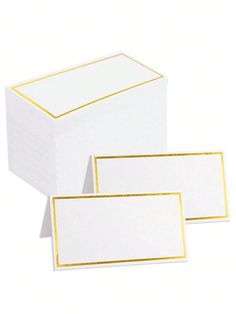 three white boxes with gold trims on them