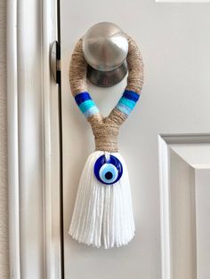 a door handle with an evil eye and tassel hanging from it's side