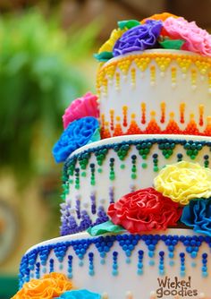 the cake is decorated with multicolored icing and has flowers on it,