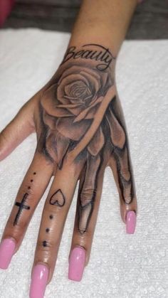 a woman's hand with tattoos on it and a rose tattooed on the palm