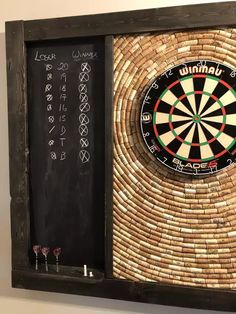 a dart board mounted to the side of a wooden frame with chalk writing on it