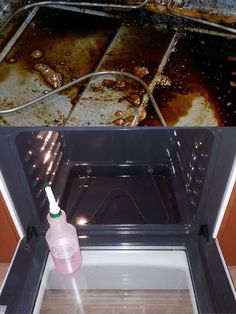 an oven door is open and there is a brown substance in the bottom right hand corner