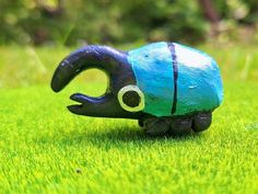 a blue and black toy sitting on top of green grass