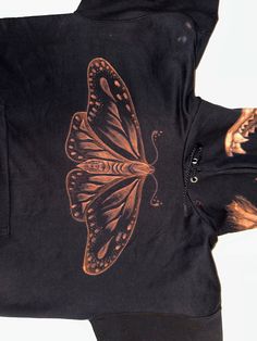 an image of a butterfly on a black hoodie that is worn by someone else