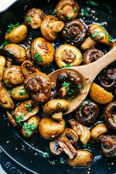 cooked mushrooms in a skillet with a wooden spoon