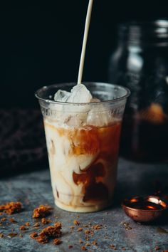 a glass filled with ice cream sitting on top of a table next to a spoon