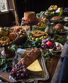 a wooden table topped with lots of different types of foods and desserts on top of it