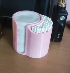 a pink toothbrush holder sitting on top of a wooden table