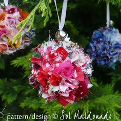 three ornaments hanging from a tree decorated with red, white and blue flowers on them