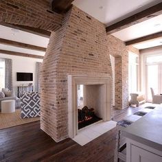 a living room filled with furniture and a fire place in the middle of a kitchen