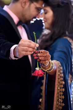 a man and woman holding a flower together