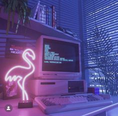 an old computer with a neon flamingo on the screen