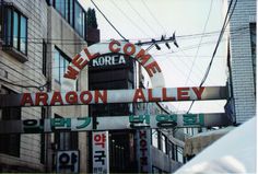 the sign for dragon alley in front of an apartment building with power lines above it