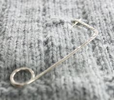 a metal pin sitting on top of a gray blanket