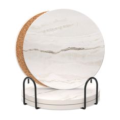 a white marble plate on a stand with a black metal holder and corked edge