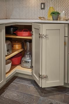 an open cabinet in the corner of a kitchen