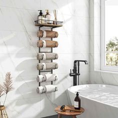 a white bath tub sitting under a window next to a shelf filled with toilet paper