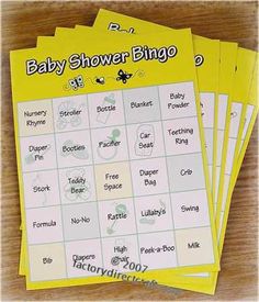 four baby shower game cards sitting on top of a wooden table