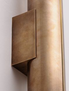 a close up of a wall light on a white wall with a gold metal frame