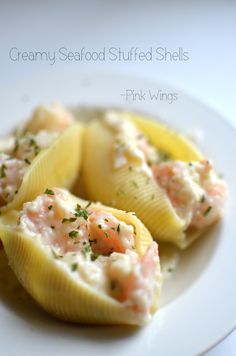 some kind of stuffed shells with shrimp and cheese on them sitting on a white plate