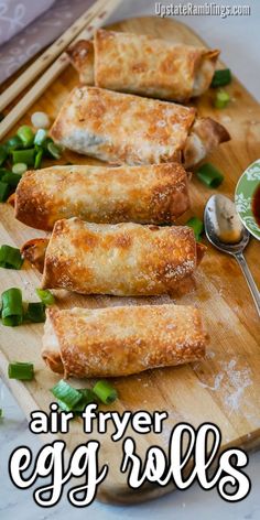 egg rolls on a cutting board with dipping sauce