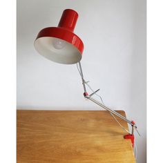 a red and white lamp sitting on top of a wooden table