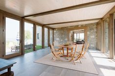 a dining table and chairs in a room with large glass doors leading to an outside patio