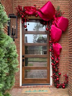 the front door is decorated with red ribbon and ornaments