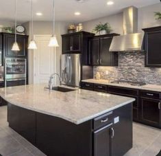 a large kitchen with granite counter tops and black cabinets