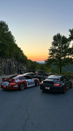 several cars parked in a parking lot at sunset