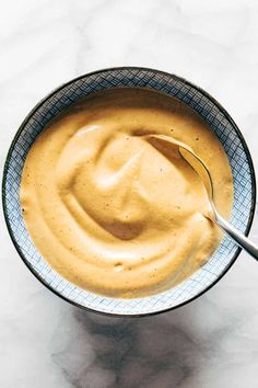 a spoon in a bowl filled with peanut butter