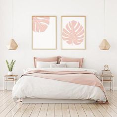 a bedroom with two paintings above the bed