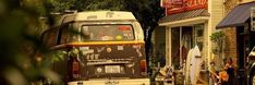 a double decker bus is parked on the side of the road in front of shops