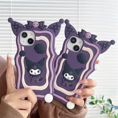 two purple cases with black and white designs on them, one is holding the other