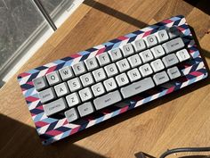 a computer keyboard sitting on top of a wooden table