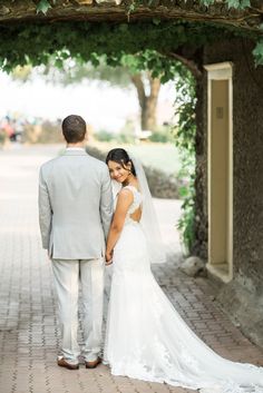 a bride and groom standing under an archway