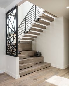 there is a stair case in the middle of this room with wood floors and white walls