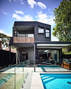 a house with a swimming pool in front of it and a deck on the other side