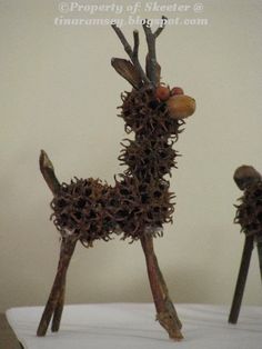 two deer sculptures made out of twigs on a table